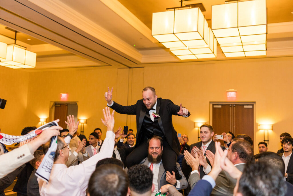 Groom being lifted up on the dance floor at a Wichita wedding reception.